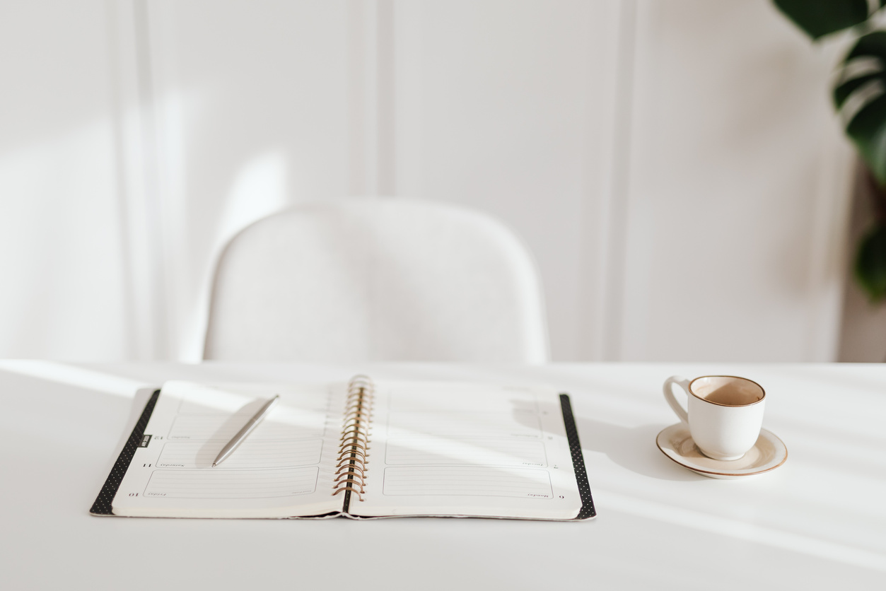 Planner, Pen and Coffee Cup on White Table